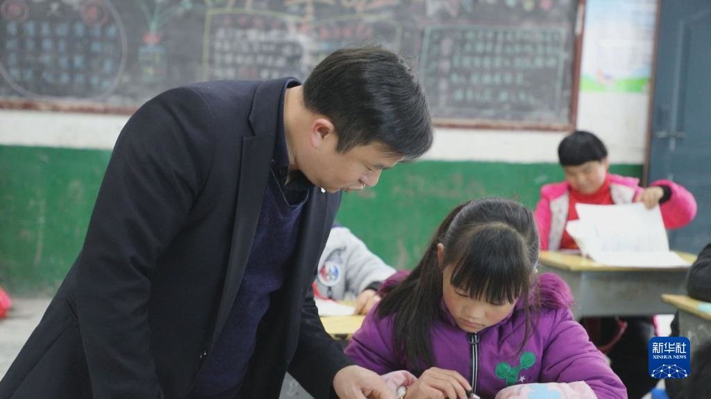 在湖南省常宁市塔山瑶族乡中心小学,盘玖仁在课堂上辅导学生(2021年11月25日摄)。新华社发(尹明 摄)